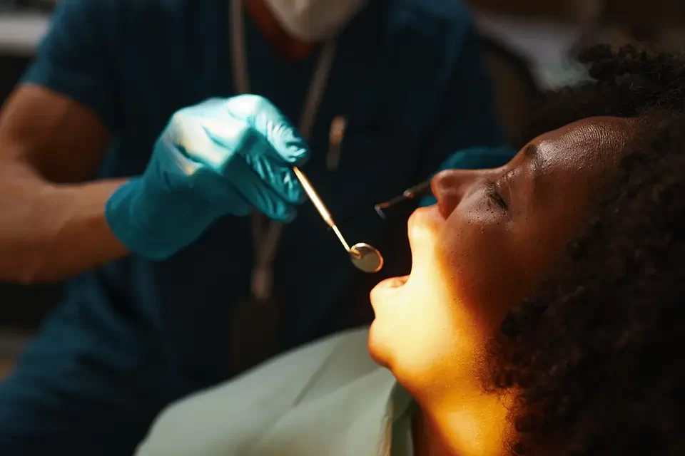 examining-patient-s-mouth-at-dental-clinic Key Benefits of Regular Oral Health Checks